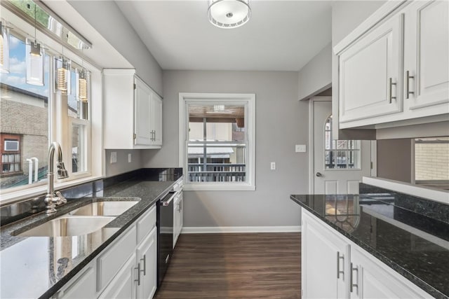 kitchen featuring white cabinetry, sink, dark stone countertops, and dark wood-type flooring