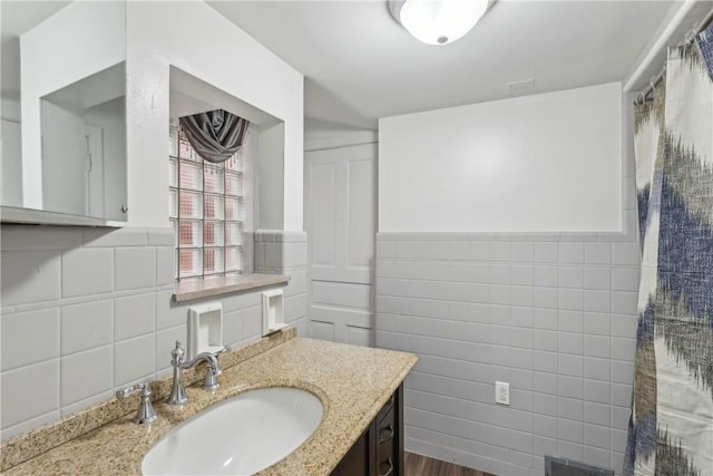 bathroom featuring vanity and tile walls