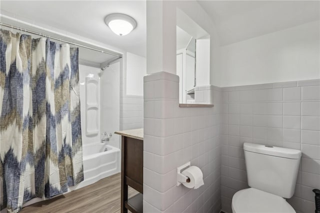 full bathroom with toilet, tile walls, hardwood / wood-style flooring, vanity, and shower / bath combination with curtain