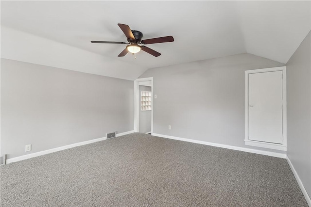 empty room with ceiling fan, lofted ceiling, and carpet flooring