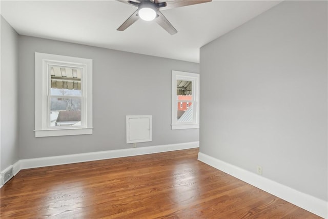 empty room with hardwood / wood-style flooring, a wealth of natural light, and ceiling fan