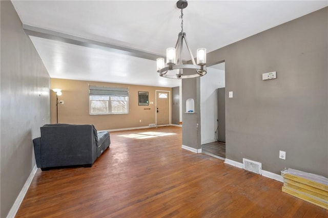 unfurnished room featuring dark wood-type flooring and an inviting chandelier