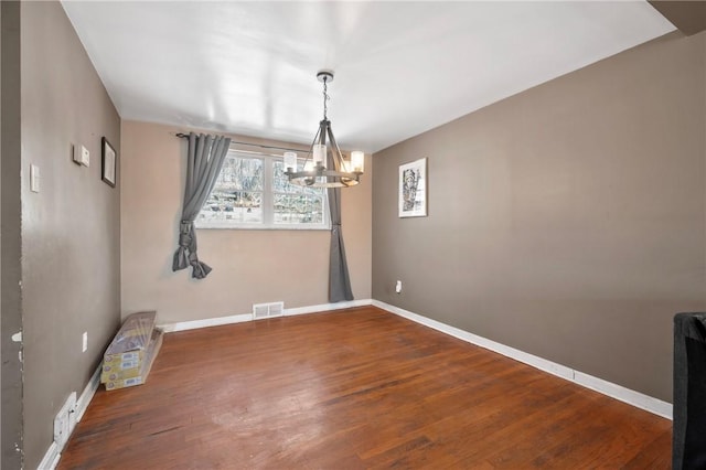 unfurnished dining area featuring hardwood / wood-style floors and a chandelier