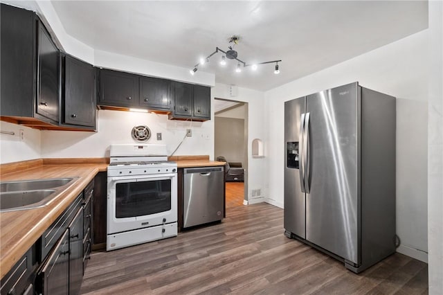 kitchen featuring sink, stainless steel appliances, dark hardwood / wood-style floors, and butcher block countertops