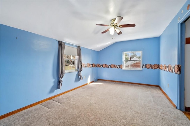 carpeted empty room featuring vaulted ceiling and ceiling fan