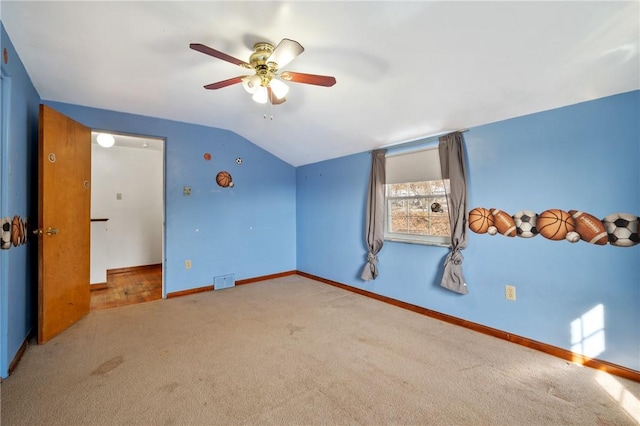 unfurnished bedroom with ceiling fan, lofted ceiling, and light carpet