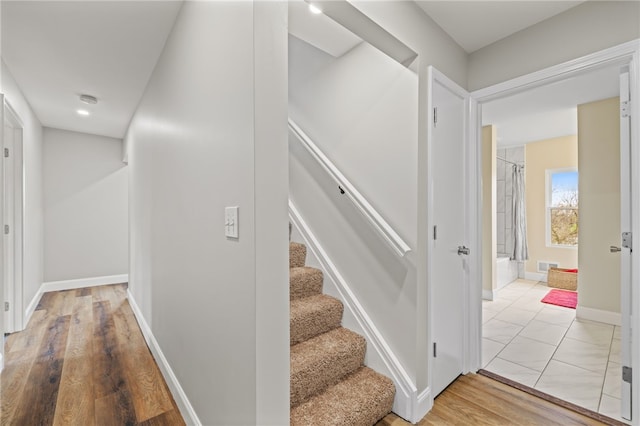 staircase with hardwood / wood-style floors