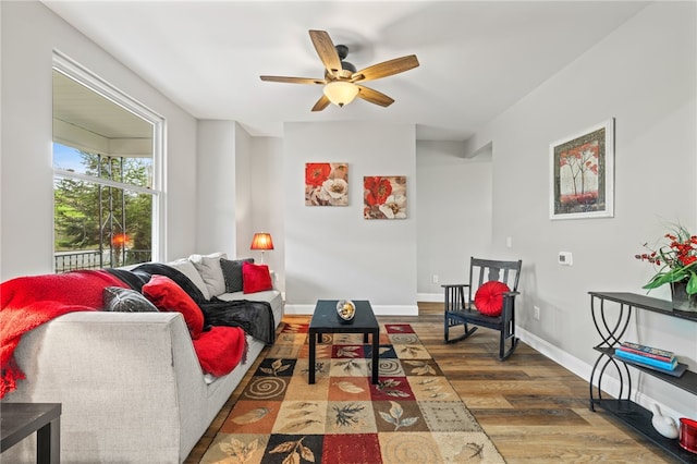 living area featuring ceiling fan, baseboards, and wood finished floors