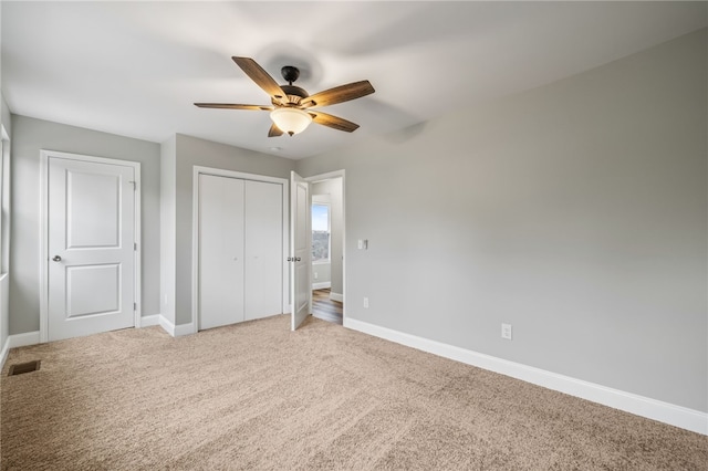 unfurnished bedroom with carpet floors, ceiling fan, and a closet