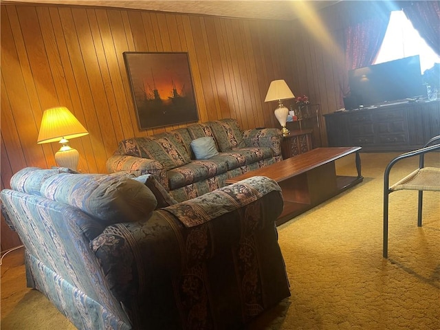 carpeted living room featuring wood walls