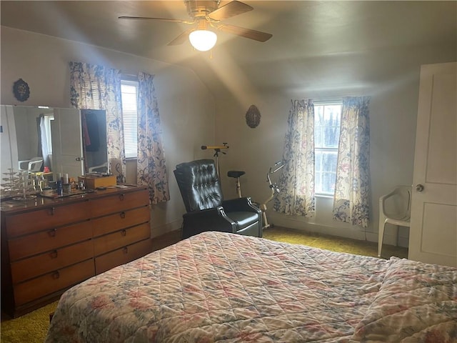 bedroom featuring multiple windows, lofted ceiling, and ceiling fan