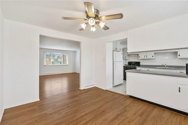 kitchen with light hardwood / wood-style flooring, white cabinetry, a baseboard heating unit, white refrigerator, and black range with gas stovetop