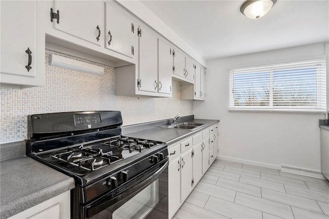 kitchen featuring backsplash, sink, gas stove, and white cabinets