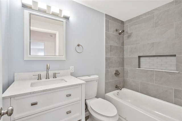 full bathroom with tiled shower / bath, vanity, and toilet