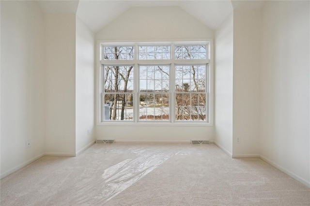 carpeted empty room featuring lofted ceiling