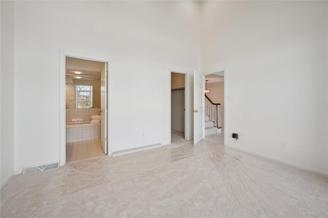 carpeted spare room with a high ceiling