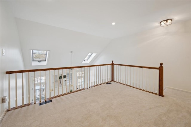 additional living space with lofted ceiling with skylight and light colored carpet