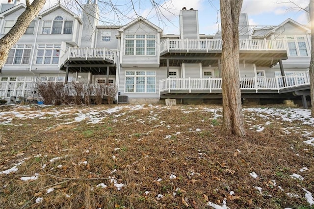 snow covered back of property featuring central air condition unit