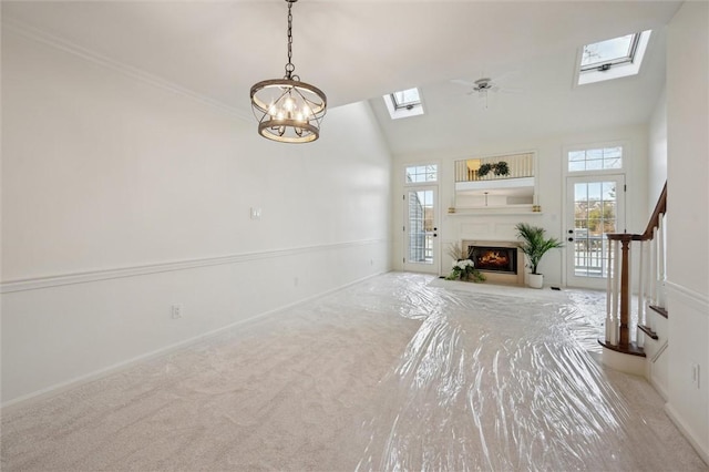 unfurnished living room featuring light carpet, a skylight, high vaulted ceiling, and ceiling fan