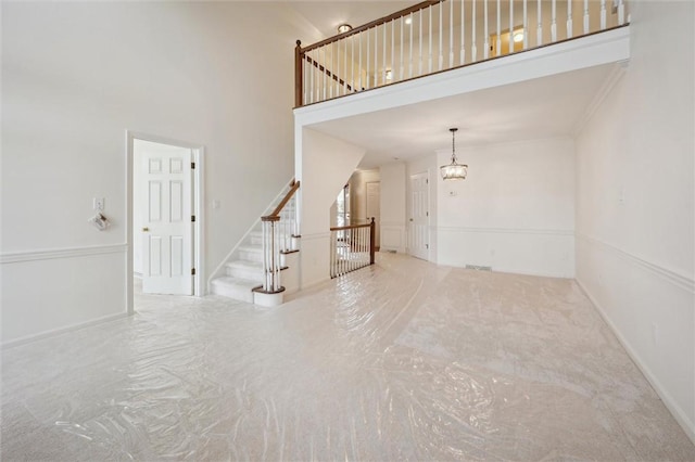 unfurnished living room featuring a towering ceiling