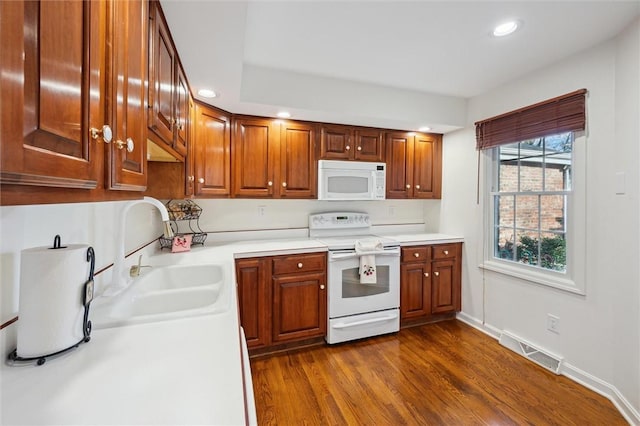 kitchen featuring sink, white appliances, and dark hardwood / wood-style floors