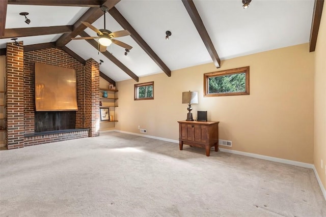 carpeted living room with a fireplace, lofted ceiling with beams, ceiling fan, and plenty of natural light