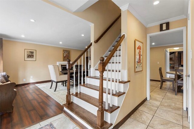 stairs with hardwood / wood-style floors and ornamental molding