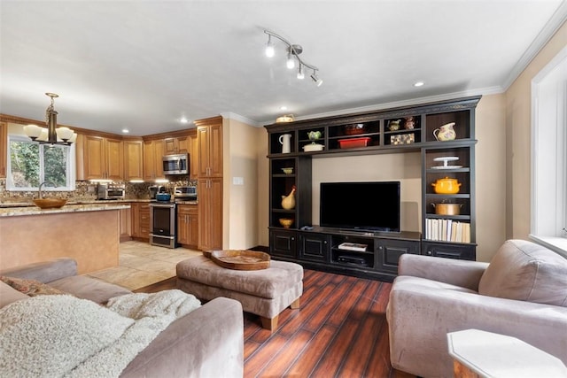 living room with ornamental molding, wood-type flooring, and a chandelier