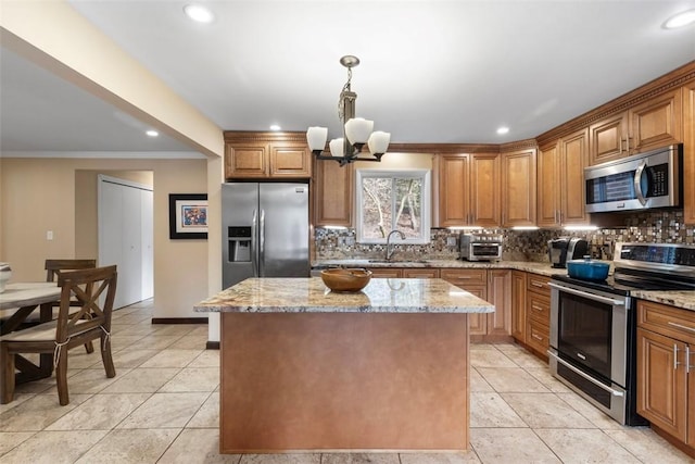 kitchen featuring a kitchen island, light stone countertops, and appliances with stainless steel finishes