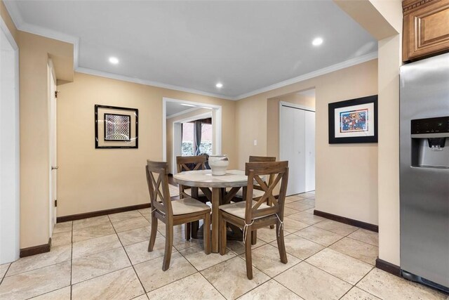 dining space featuring ornamental molding and light tile patterned floors