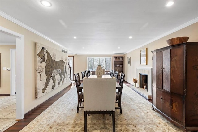 dining room featuring crown molding, dark hardwood / wood-style floors, and a fireplace