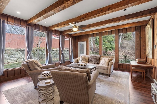 sunroom / solarium featuring ceiling fan and beam ceiling