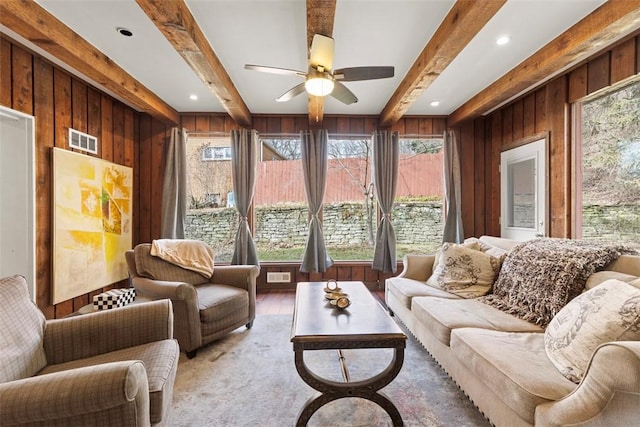 sunroom / solarium featuring ceiling fan and beamed ceiling