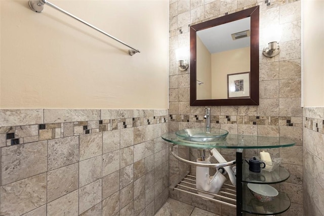 bathroom with sink and tile walls