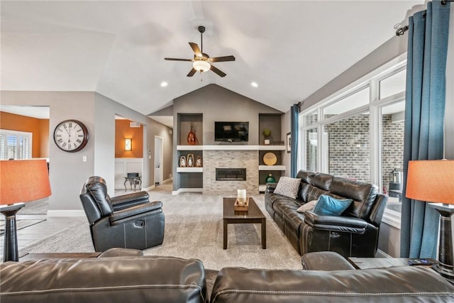 carpeted living room featuring built in shelves, vaulted ceiling, and ceiling fan