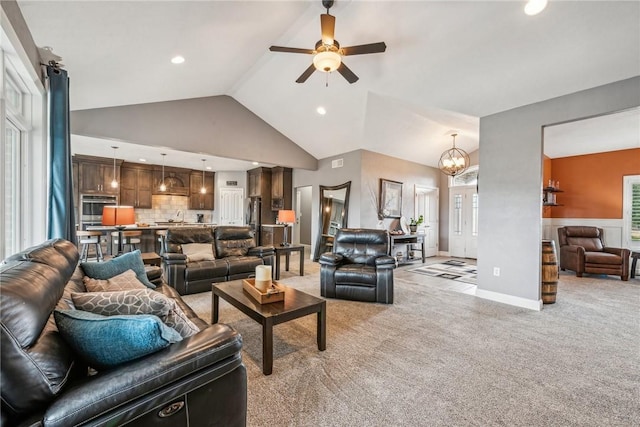 living room featuring sink, ceiling fan with notable chandelier, light colored carpet, and high vaulted ceiling