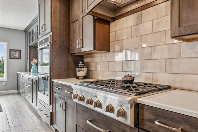 kitchen featuring tasteful backsplash, appliances with stainless steel finishes, and dark brown cabinetry