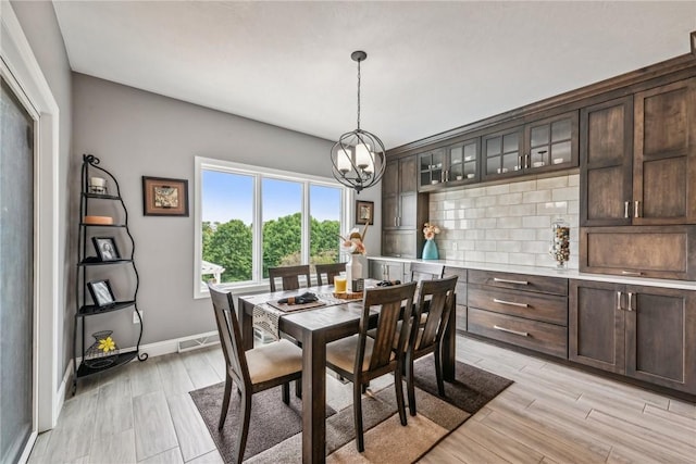 dining space with a notable chandelier and light hardwood / wood-style floors