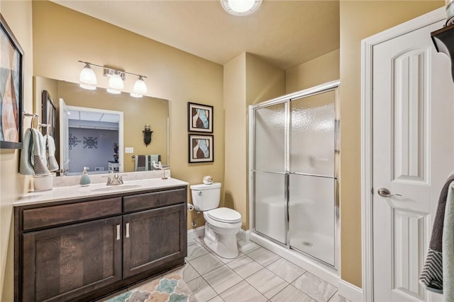 bathroom with tile patterned floors, vanity, toilet, and an enclosed shower