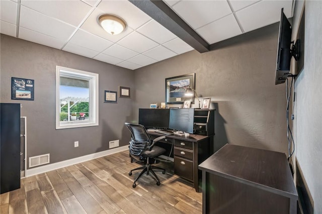 office featuring a paneled ceiling and light hardwood / wood-style floors