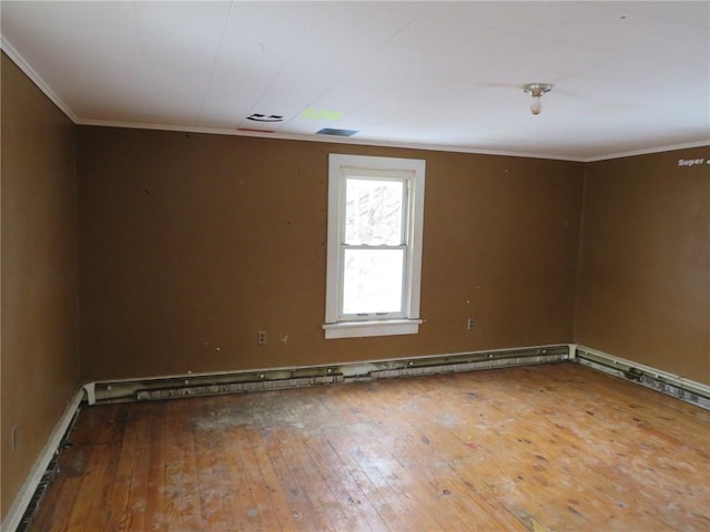 spare room featuring wood-type flooring, ornamental molding, and baseboard heating