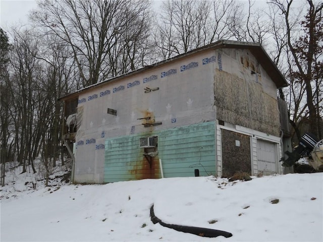 snow covered property with a garage