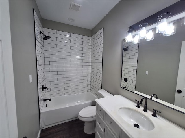 full bathroom featuring tiled shower / bath, wood-type flooring, vanity, and toilet