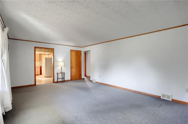 empty room featuring crown molding and carpet floors