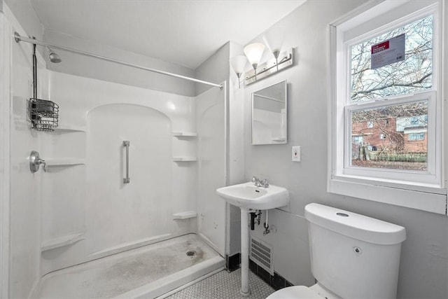 bathroom featuring a shower, sink, and toilet