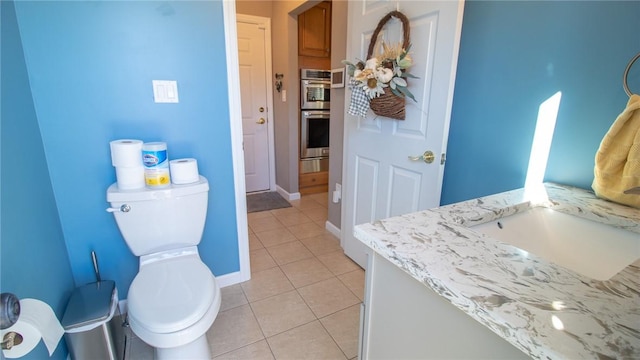 bathroom with tile patterned flooring, vanity, and toilet