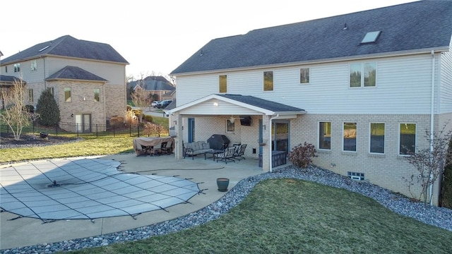 back of property with a lawn and a patio