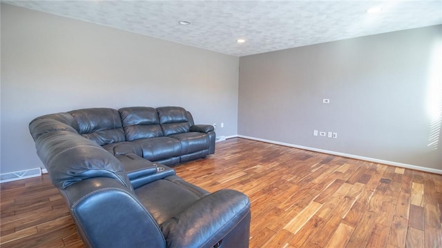 living room featuring dark wood-type flooring and a textured ceiling