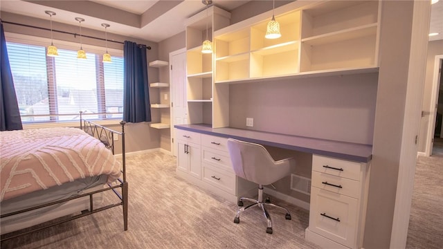 carpeted bedroom featuring built in desk