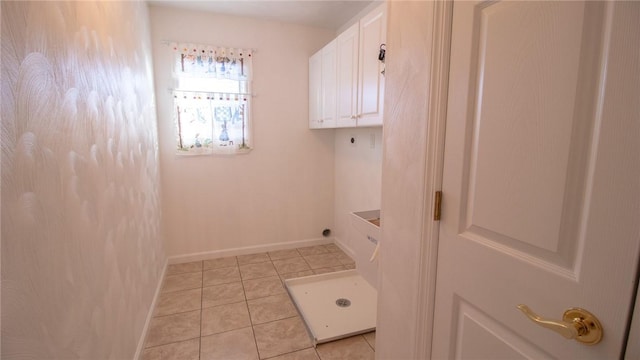 washroom with cabinets, electric dryer hookup, and light tile patterned floors